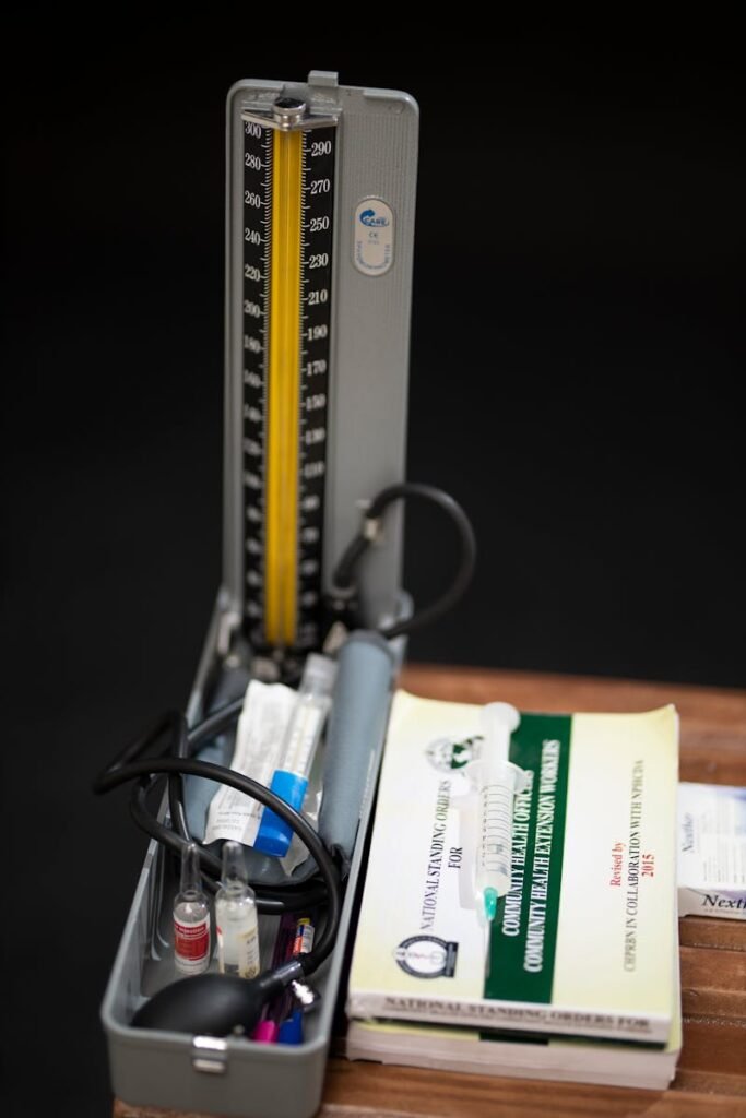 Close-up of a sphygmomanometer and medical textbook on a dark background.